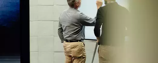 two people at a whiteboard 