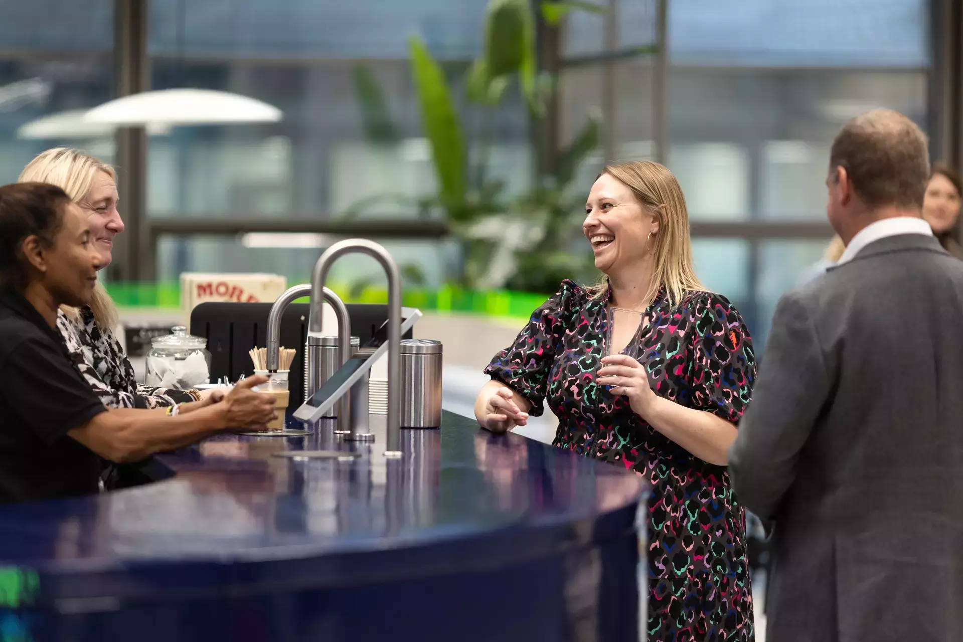 people_colleagues_talking_and_laughing_using_coffee_machine