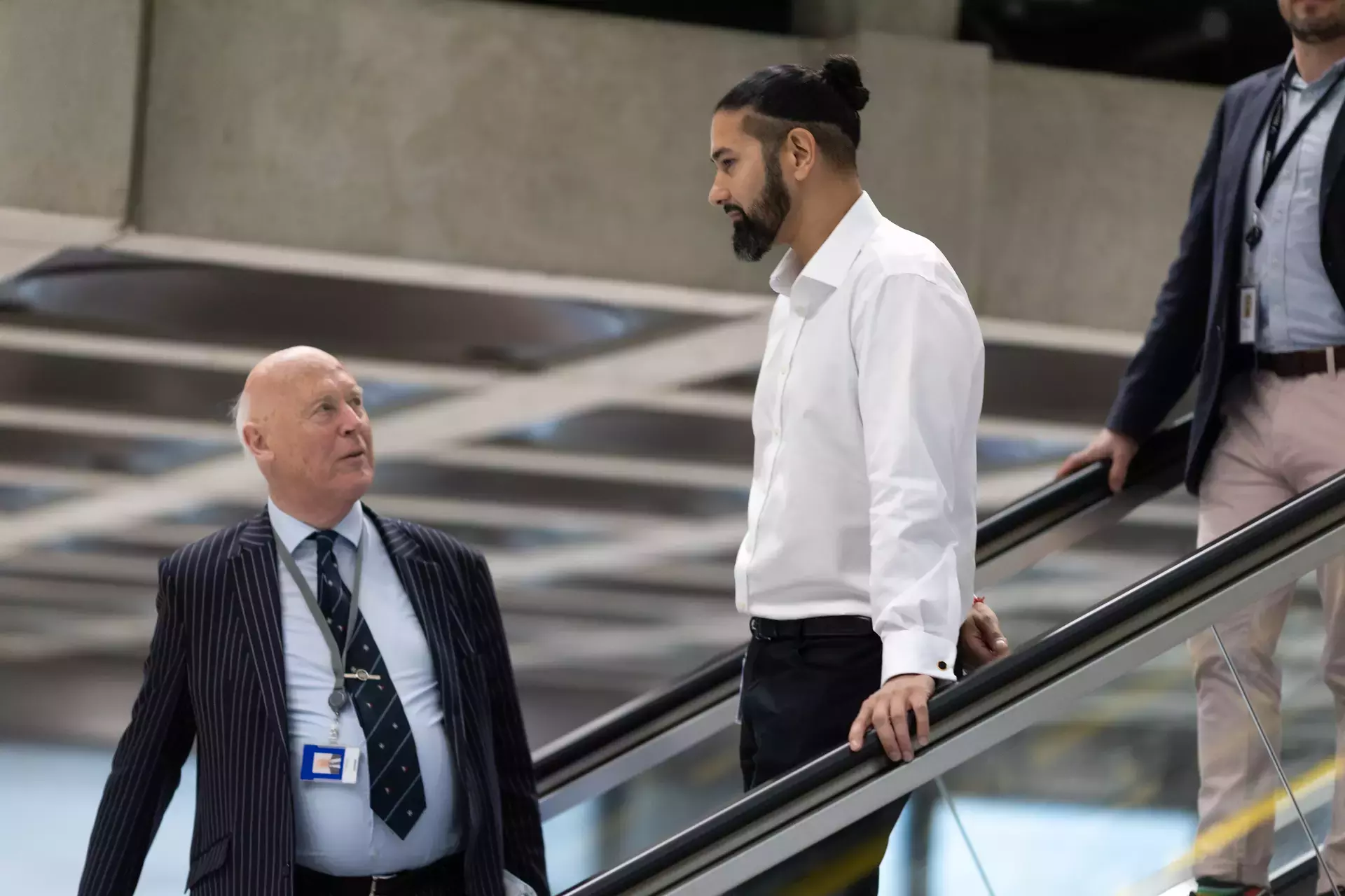 people_colleagues_talking_going_down_the_escalator