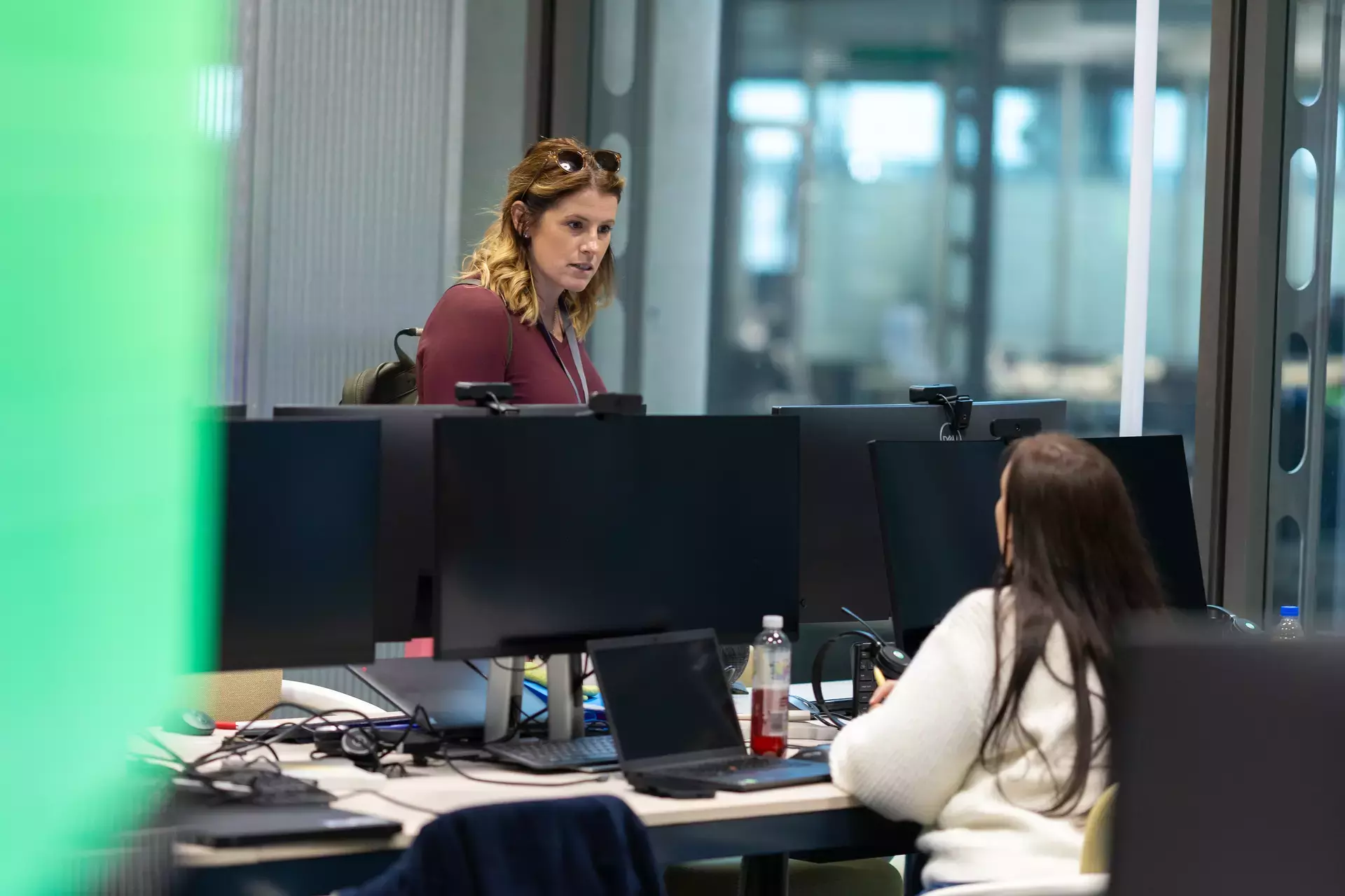 people_colleagues_talking_in_office_infront_of_lapto