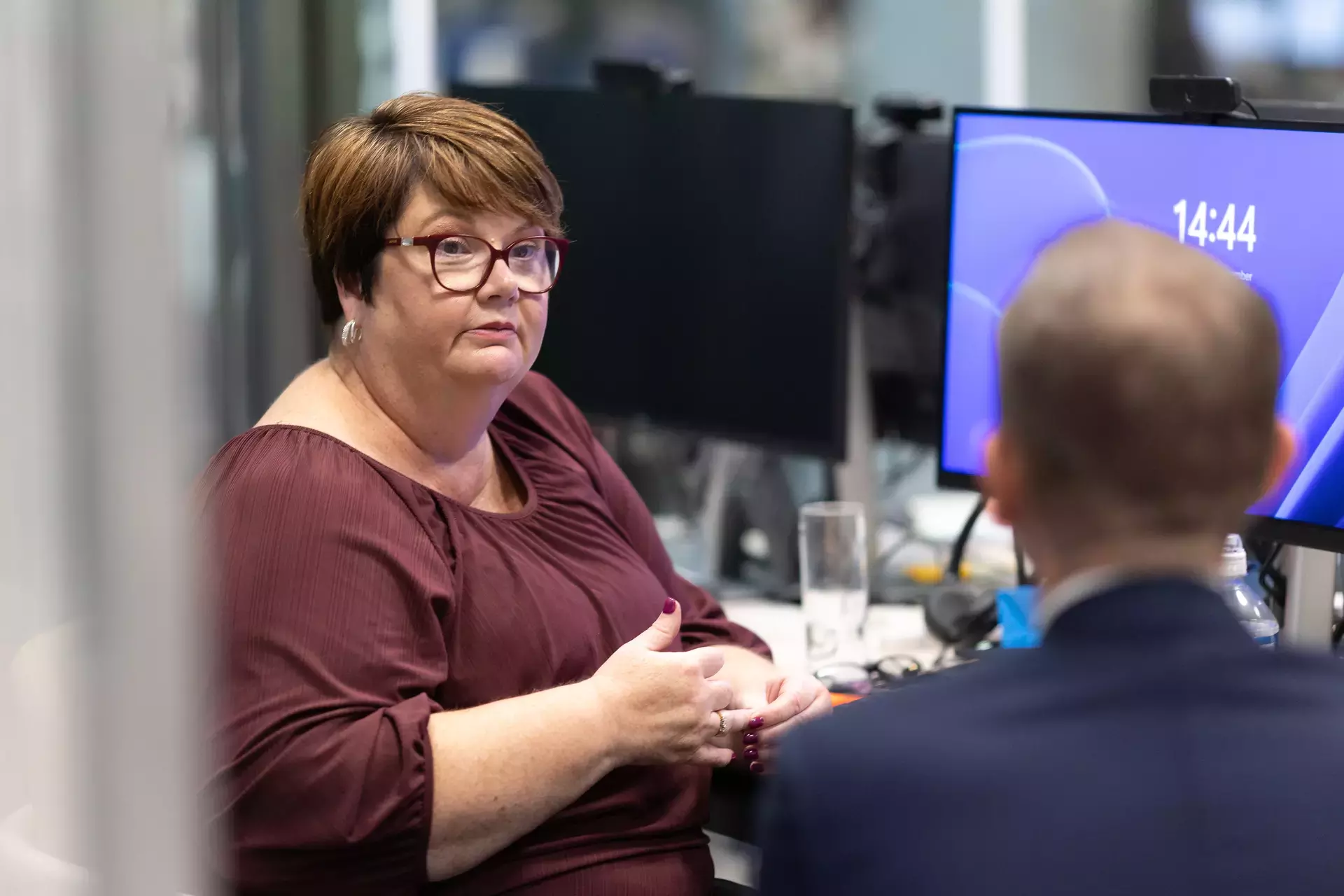 people_colleagues_talking_in_office_infront_off_laptop