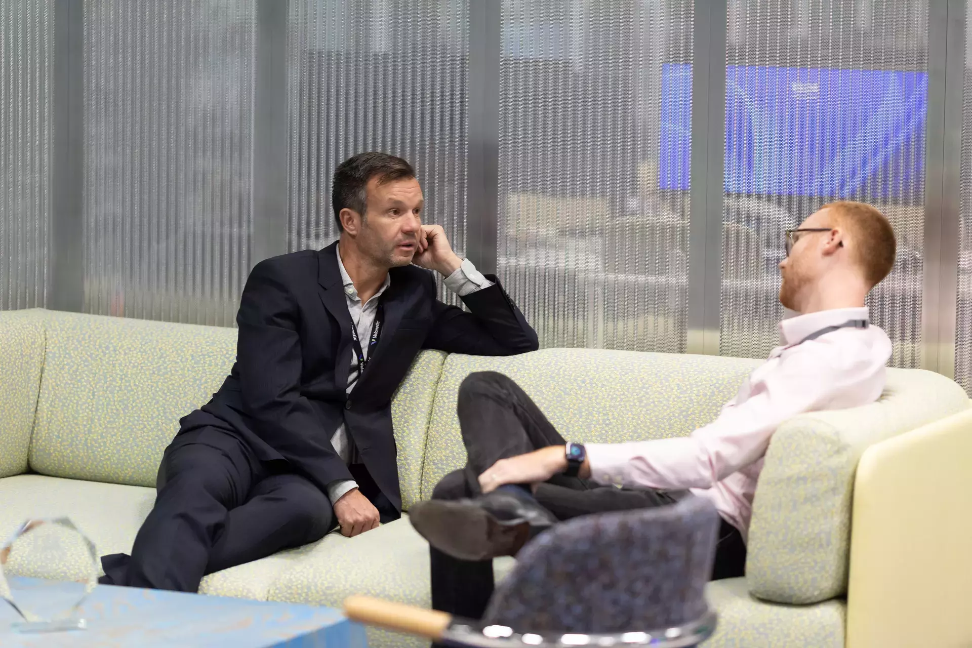 people_colleagues_talking_on_sofas_in_office_communall_area